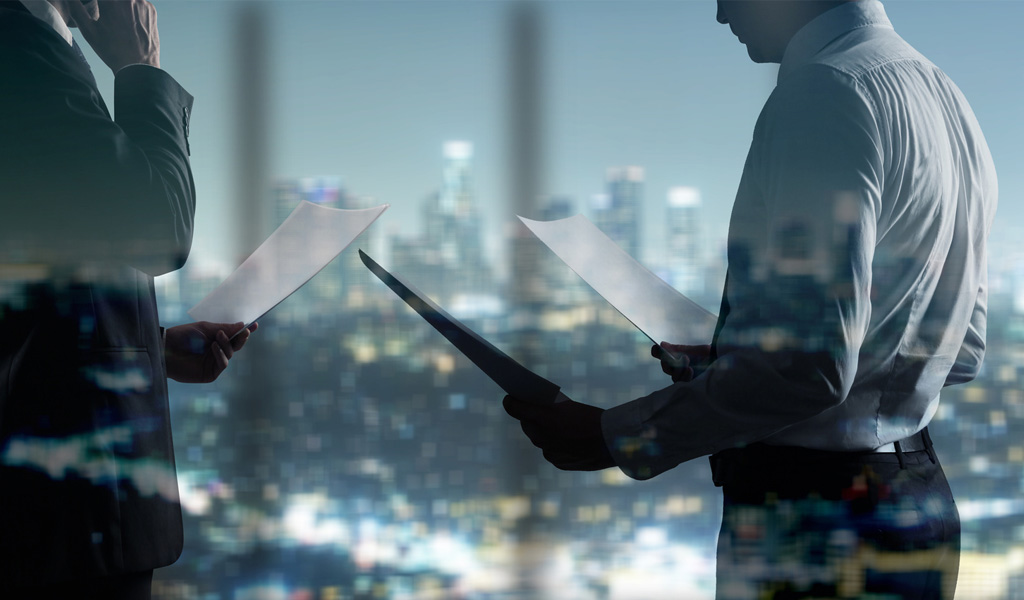 businessman with paper standing in night office